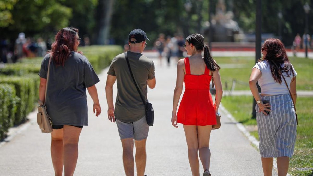 Un grup de joves passeja per un parc.