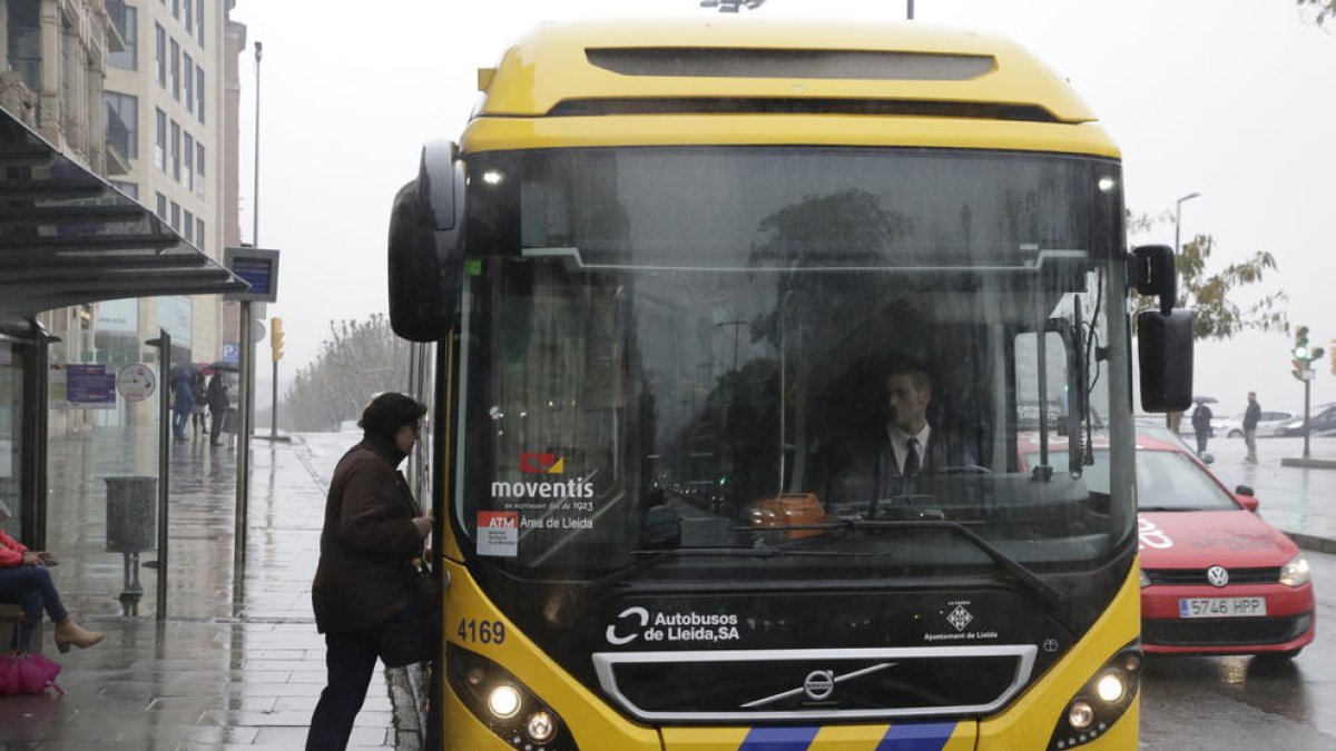 Una usuària puja a un autobús a la parada davant de la Paeria.