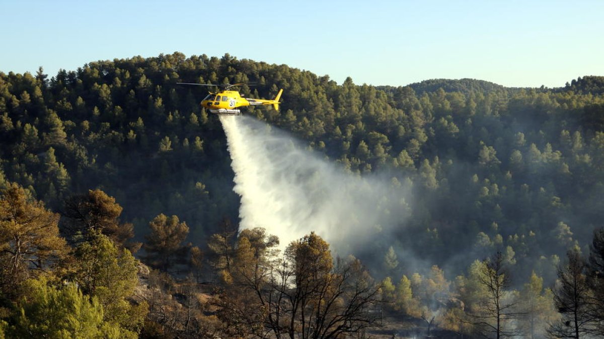 Un helicòpter descarregant aigua sobre l’incendi.