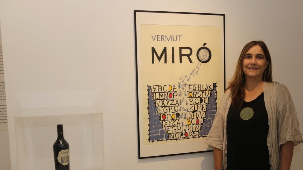 La artista ganadora Núria Rossell, ayer junto a su obra y la botella de Vermuts Miró.