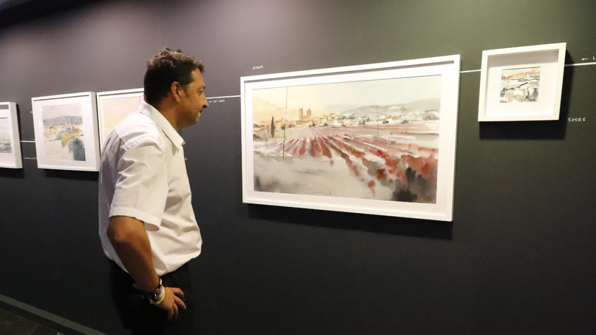 Un dels visitants a l’exposició contempla una aquarel·la a la Sala Montsuar de l’IEI.