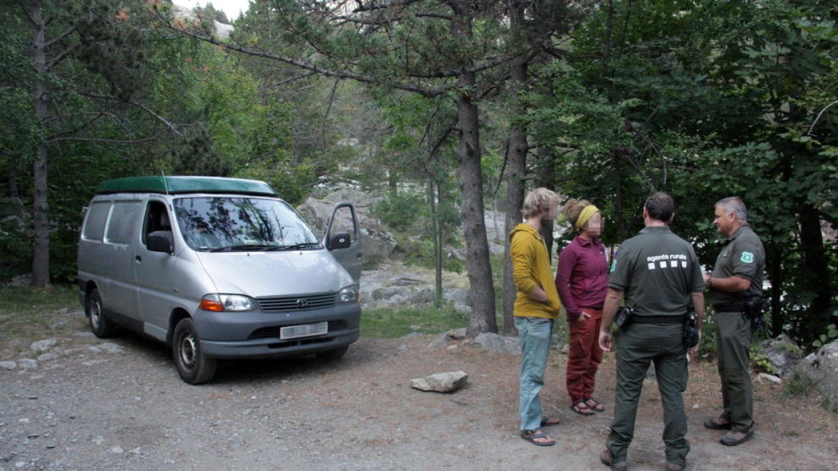 Agentes Rurales informan de la normativa a una pareja de visitantes del Parque Nacional de Aigüestortes.