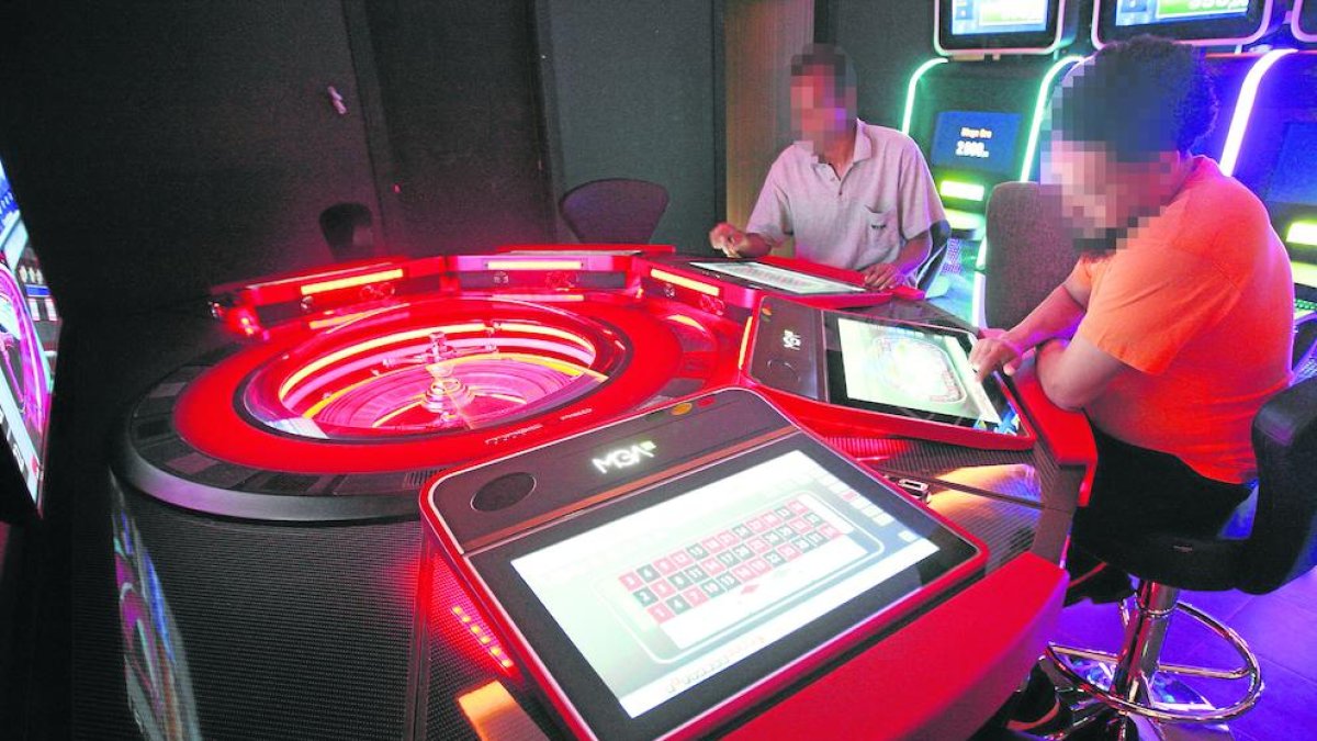 Imatge de dos persones en una sala de jocs.