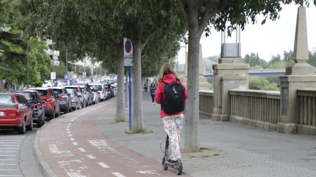 Una usuaria de un patinete eléctrico en la avenida del Segre.