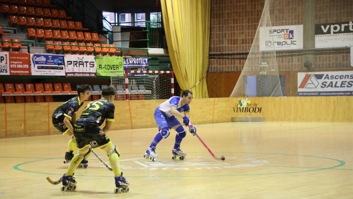 Andreu Tomàs controla la bola ante dos jugadores del Caldes.