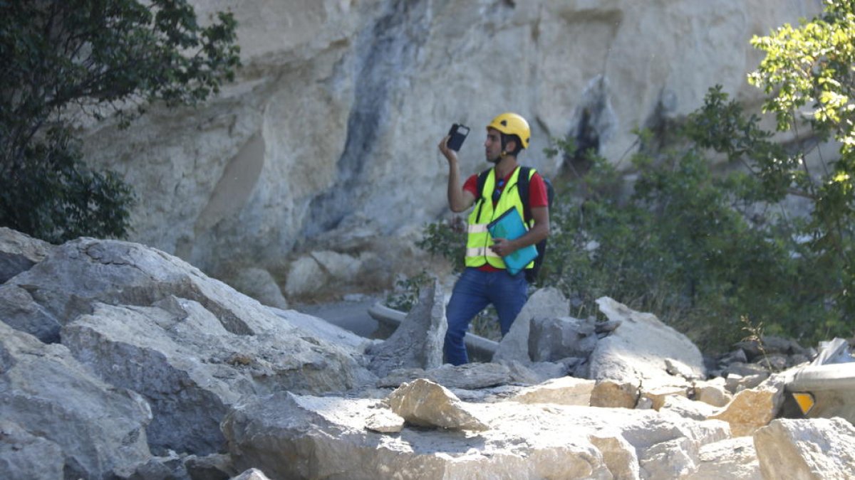 Un tècnic de l'empresa contractada pel consistori, ahir entre les roques caigudes sobre la calçada.