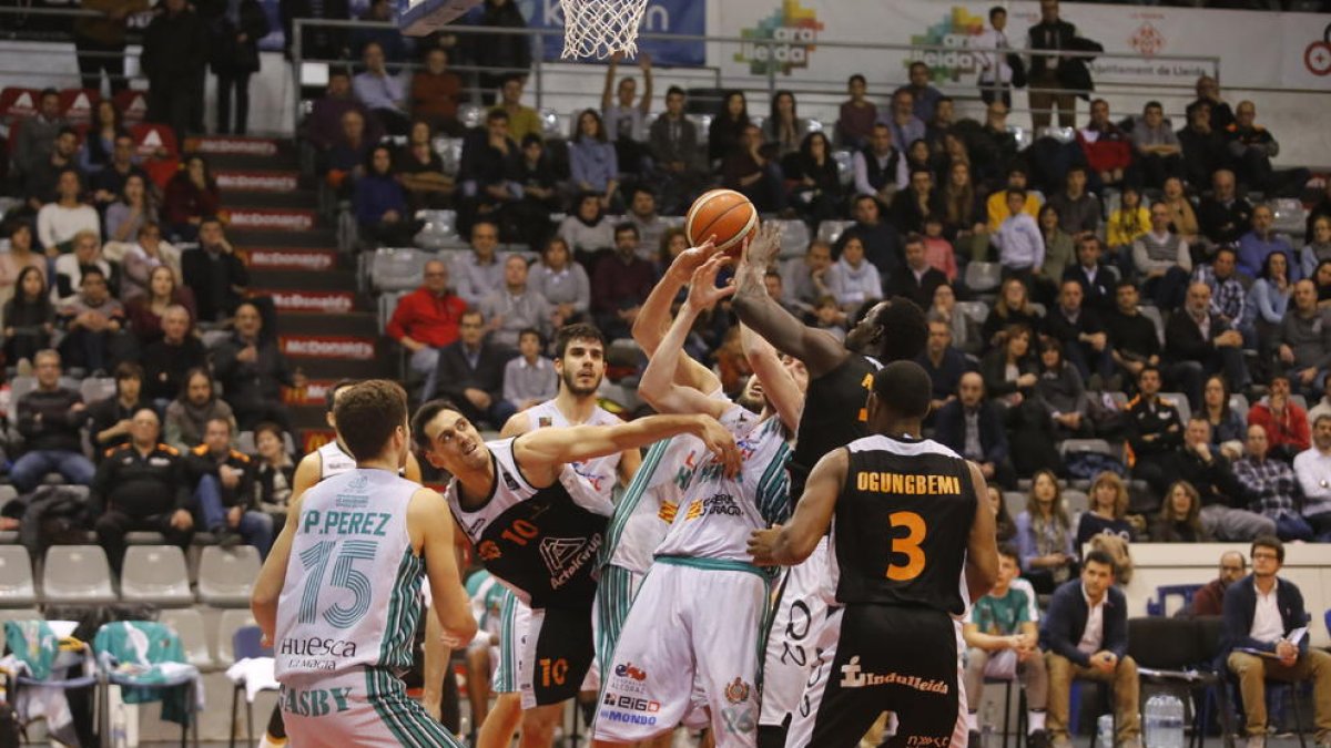 Miki Feliu, Mbaye i Ogungbemi-Jackson lluiten per una pilota contra diversos jugadors de l’Osca, en una acció del partit d’ahir.