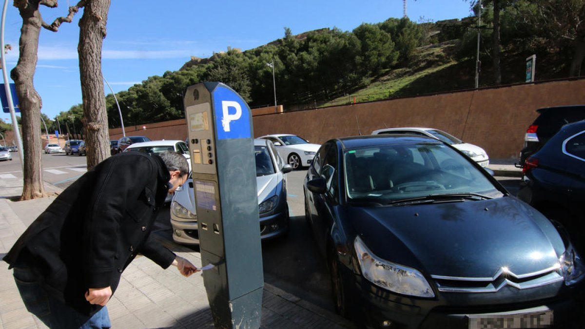 Un conductor anulando ayer una sanción en un parquímetro en la ciudad de Lleida.