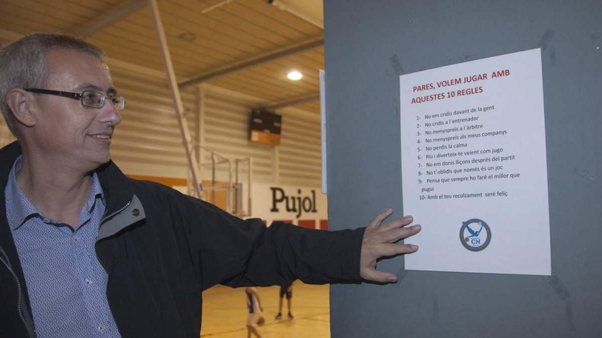 Santi Vergé muestra uno de los carteles que hay colgados en el pabellón donde juega el CN Tàrrega.