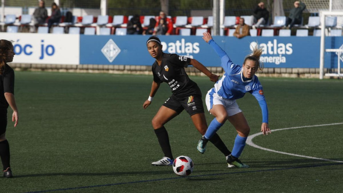 Una jugadora de l’AEM lluita pel control de la pilota en una acció del partit.