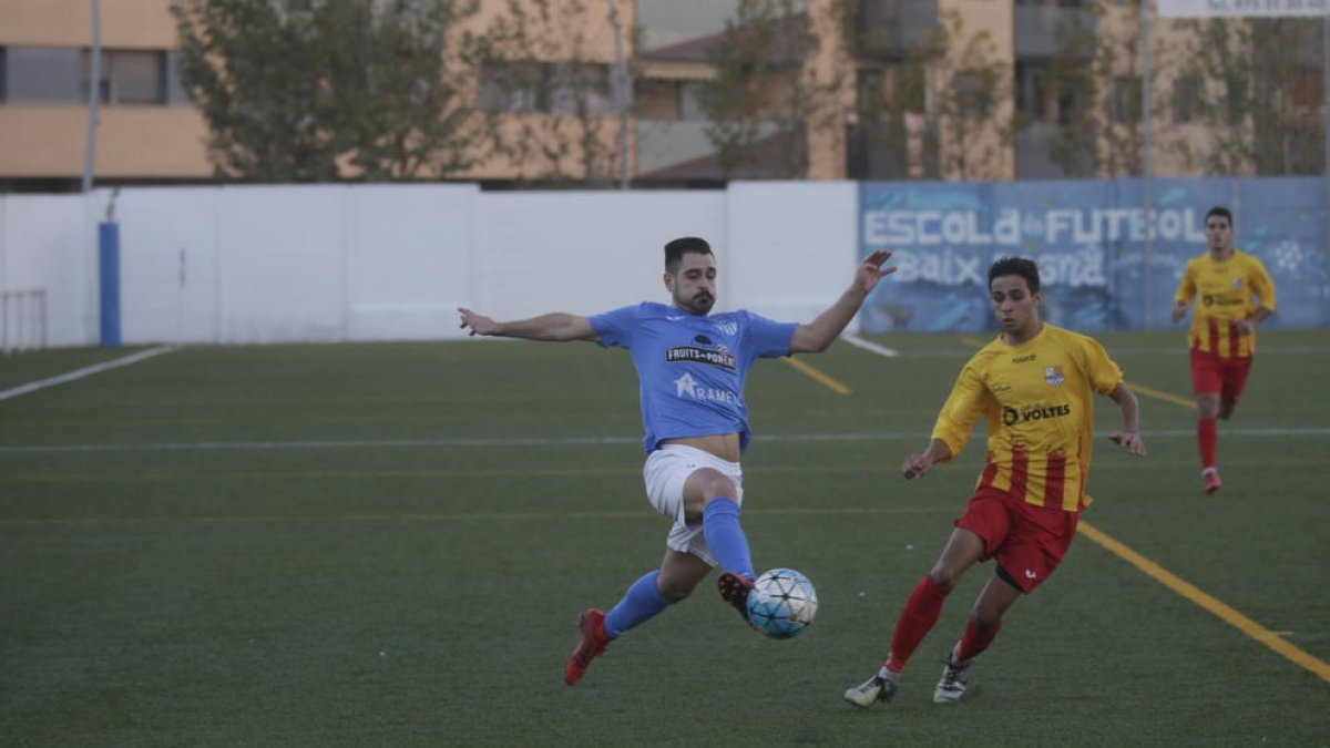 Un jugador de l’Alcarràs colpeja la pilota davant la pressió rival. 