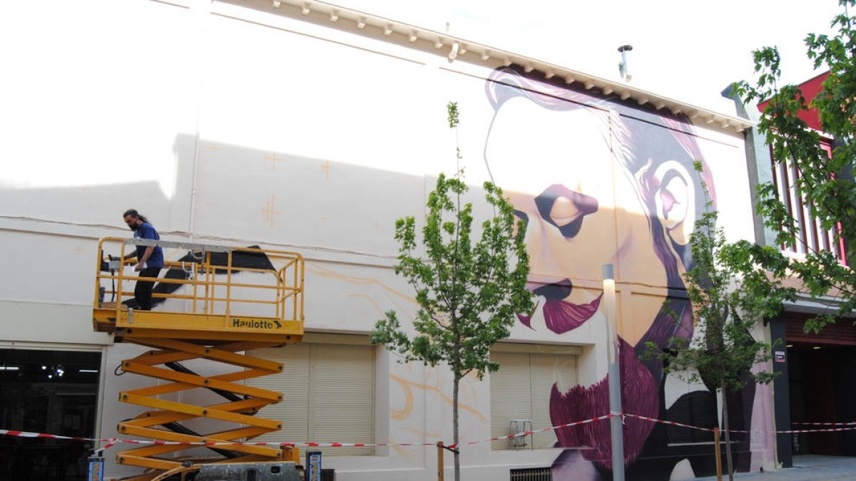 L’artista Sergi Gaya, ahir en plena acció pictòrica del mural en una façana de L’Amistat.