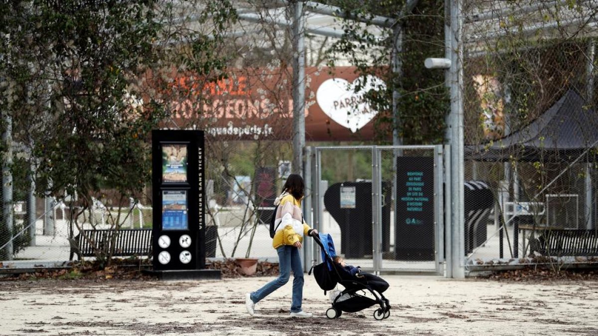 Una dona passa per davant de la porta tancada del zoo de París.