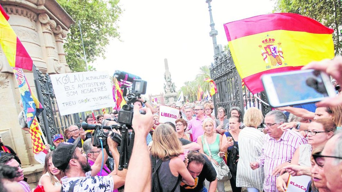 El càmera, ajupit al centre amb samarreta negra, després de ser agredit ahir a la Ciutadella.