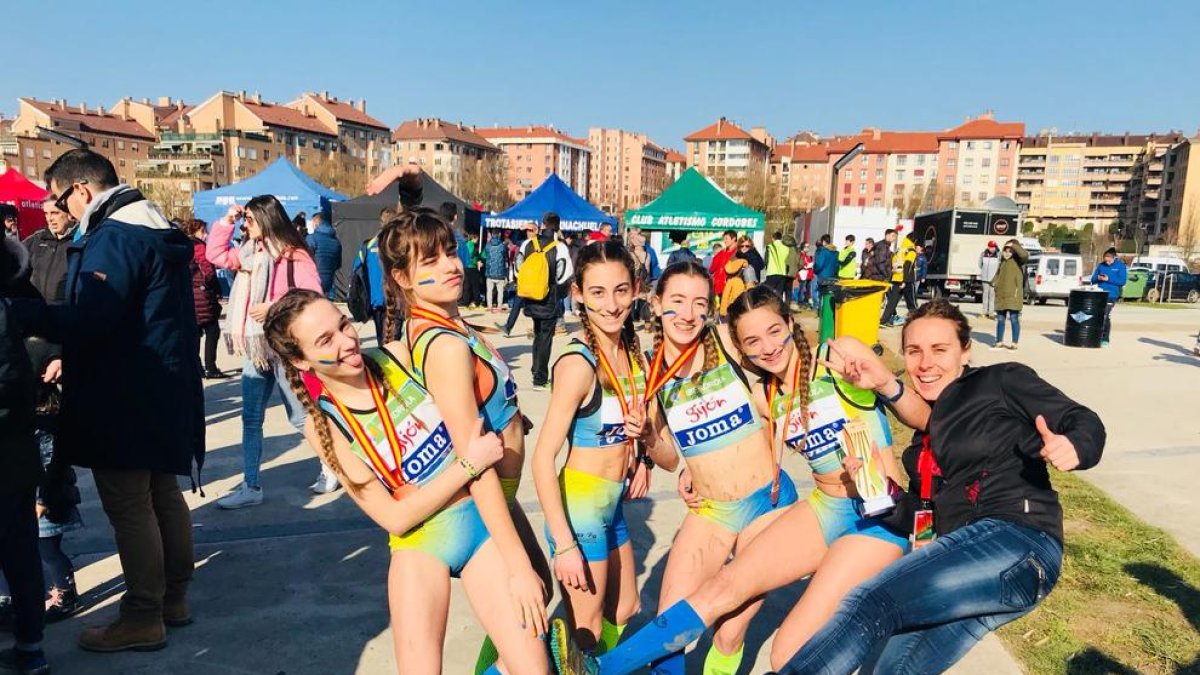 Les atletes del JA Arbeca i la seua entrenadora, Sandra Sarri, celebren la medalla de bronze a Gijón.