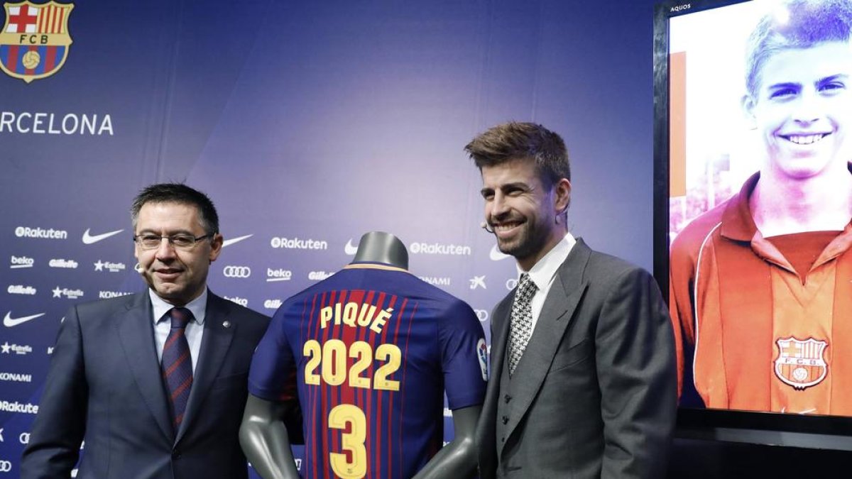 Bartomeu i Gerard Piqué flanquegen la samarreta que explicita la renovació del central fins al 2022.