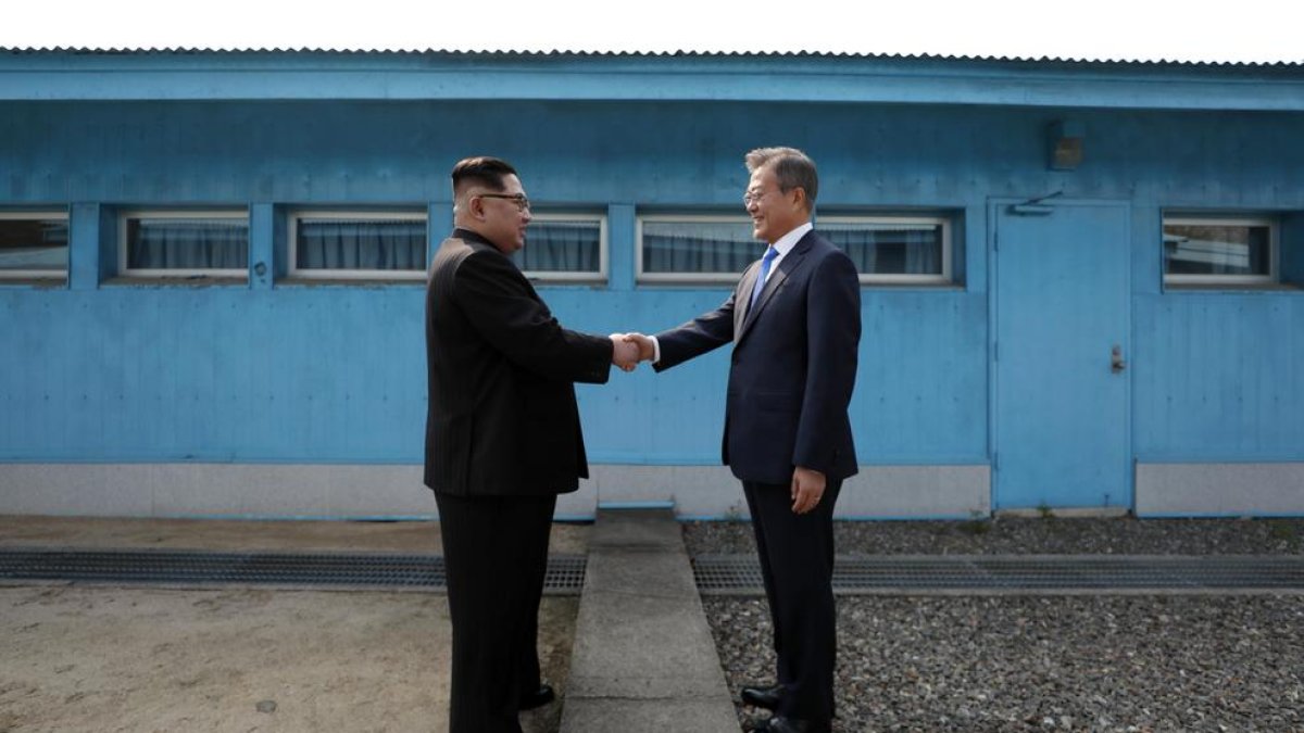 Kim Jong-un y Moon Jae-in se dan la mano en la línea de demarcación militar (MDL) entre ambos países.