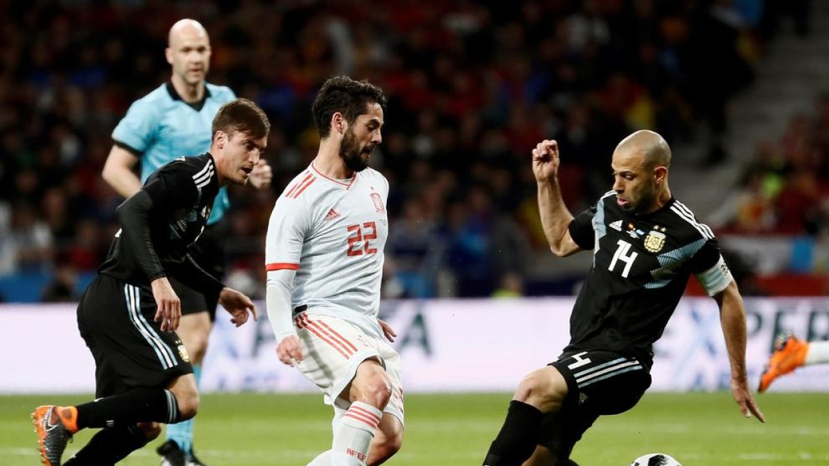 Isco, autor de un ‘hat trick’, supera al exazulgrana Mascherano ayer en el amistoso entre España y Argentina. 