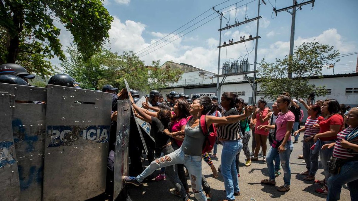 Un grupo de familiares de presos protesta ante miembros de la Policía.