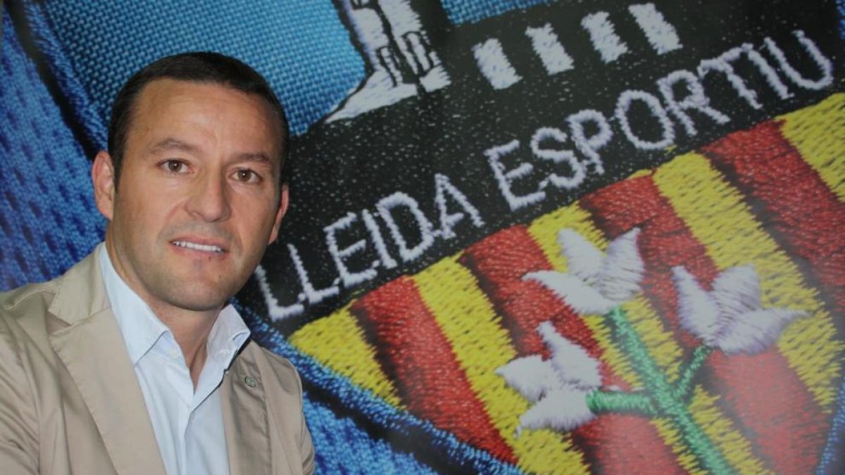 El president del Lleida, Albert Esteve, al costat de l’escut de l’entitat al Camp d’Esports.