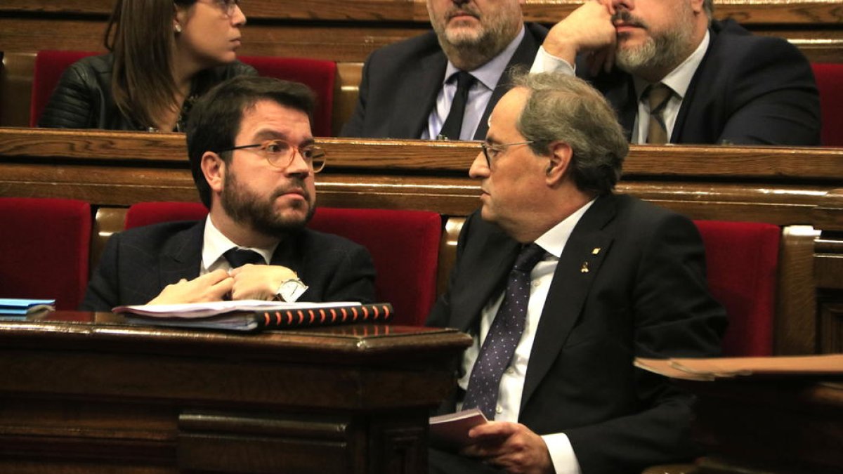 El president del Govern, Quim Torra, parlant amb el vicepresident, Pere Aragonès, en un ple al Parlament.