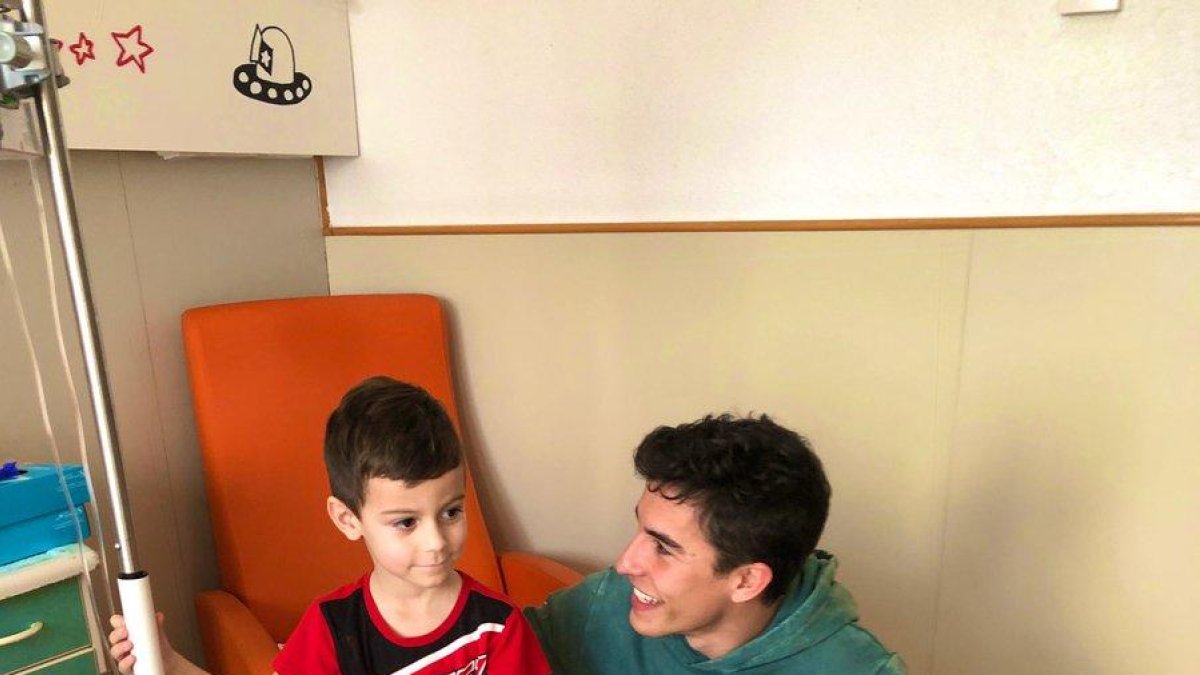 Marc Màrquez entrega una Copa a uno de los niños ingresados.