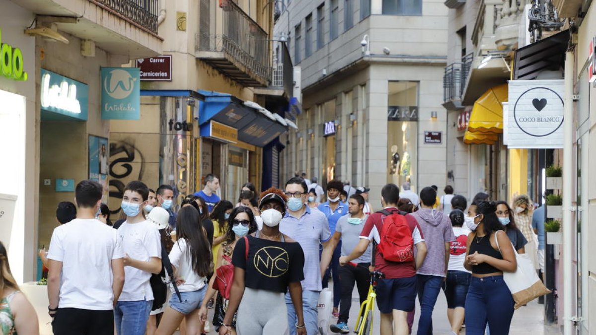 El Eix Comercial, ayer por la tarde con compradores y peatones ataviados en su mayoría con mascarillas. 