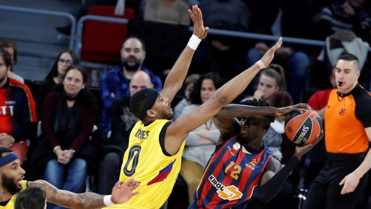 El barcelonista Davies intenta impedir el pase de Diop.