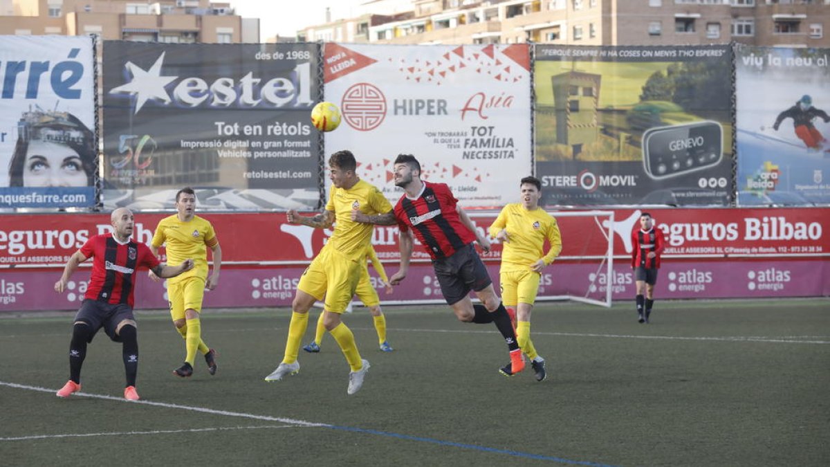 Pau Bosch disputa una pilota aèria amb un futbolista del Vilanova.