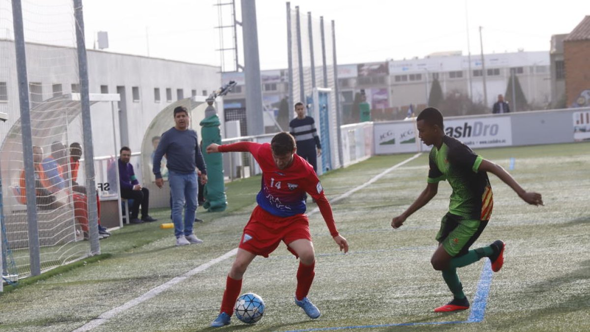 Un jugador del Torrefarrera conduce el balón ante la vigilancia de un defensor del Cervera.