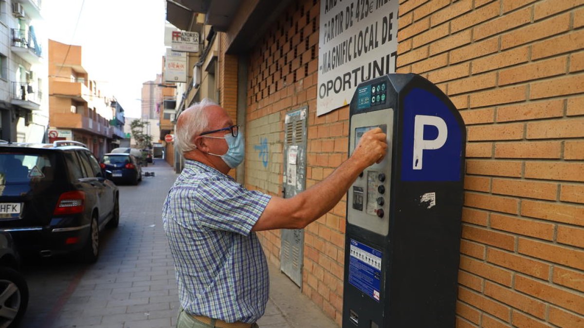 Un ciutadà al pagar la taxa de zona blava a Lleida.