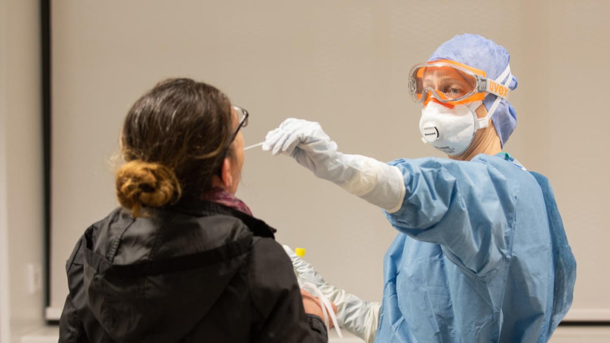 Una professional sanitària agafa una mostra per fer una prova de coronavirus a l'Hospital Clínic