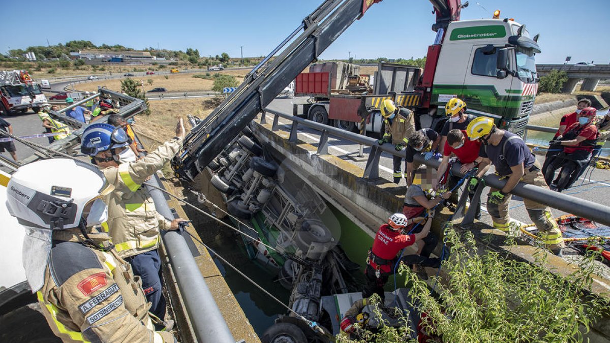 Deu dotacions de bombers treballen per excarcerar el conductor d'un camió que ha caigut al canal de Balaguer a Alcoletge