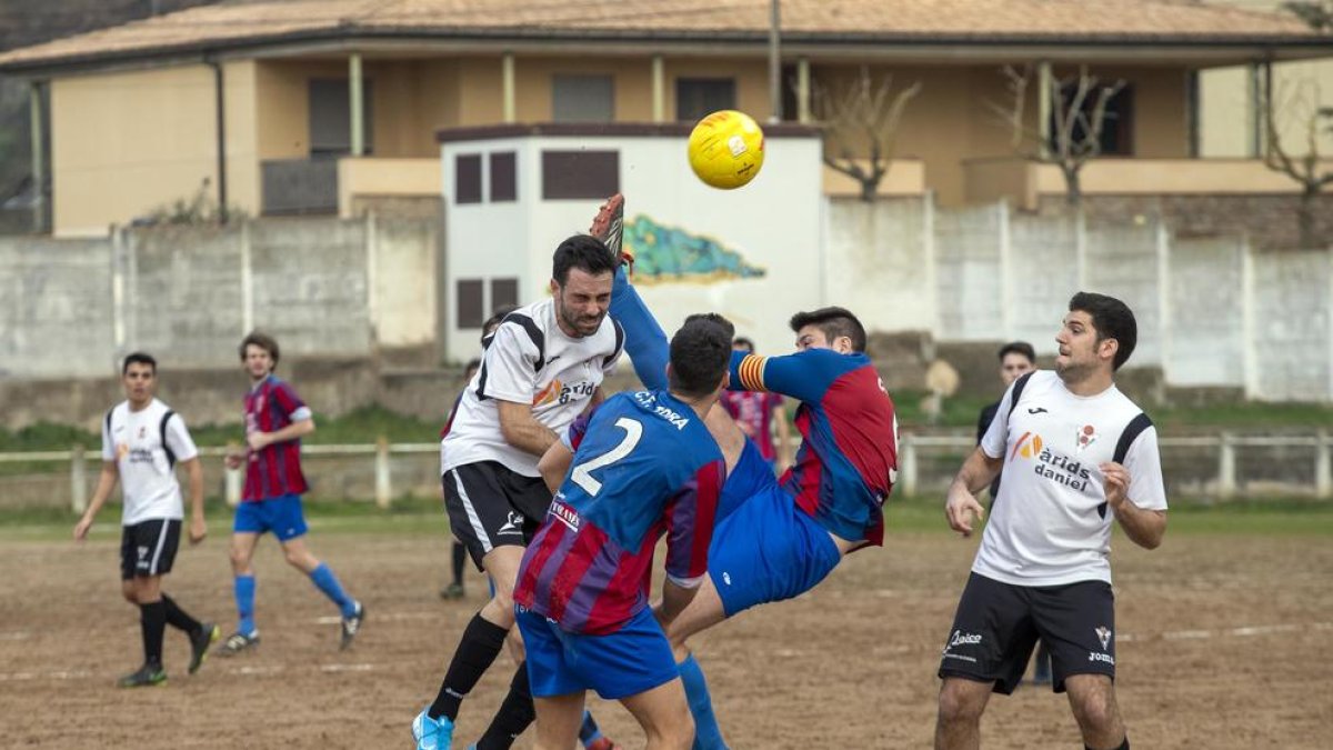 Jugadors del Vallfogona i del Torà es disputen la possessió de la pilota. 