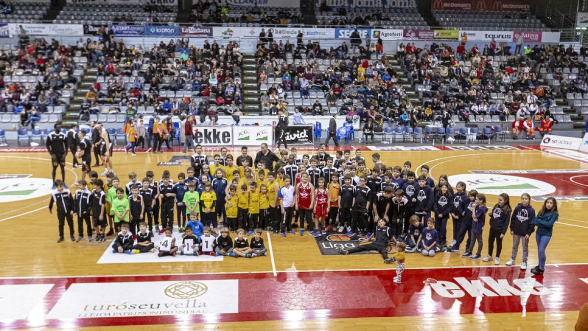 Todos los jugadores de los diferentes clubes que participaron, durante el descanso del partido de ayer, en el Dia del Bàsquet Lleidatà.