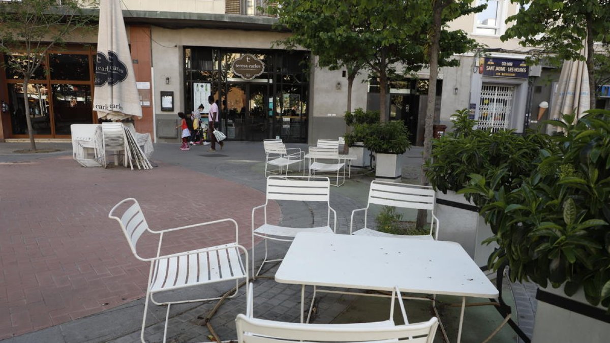 Part de la terrassa d’un local de restauració de Lleida, amb cadires i taules desplegades al carrer.