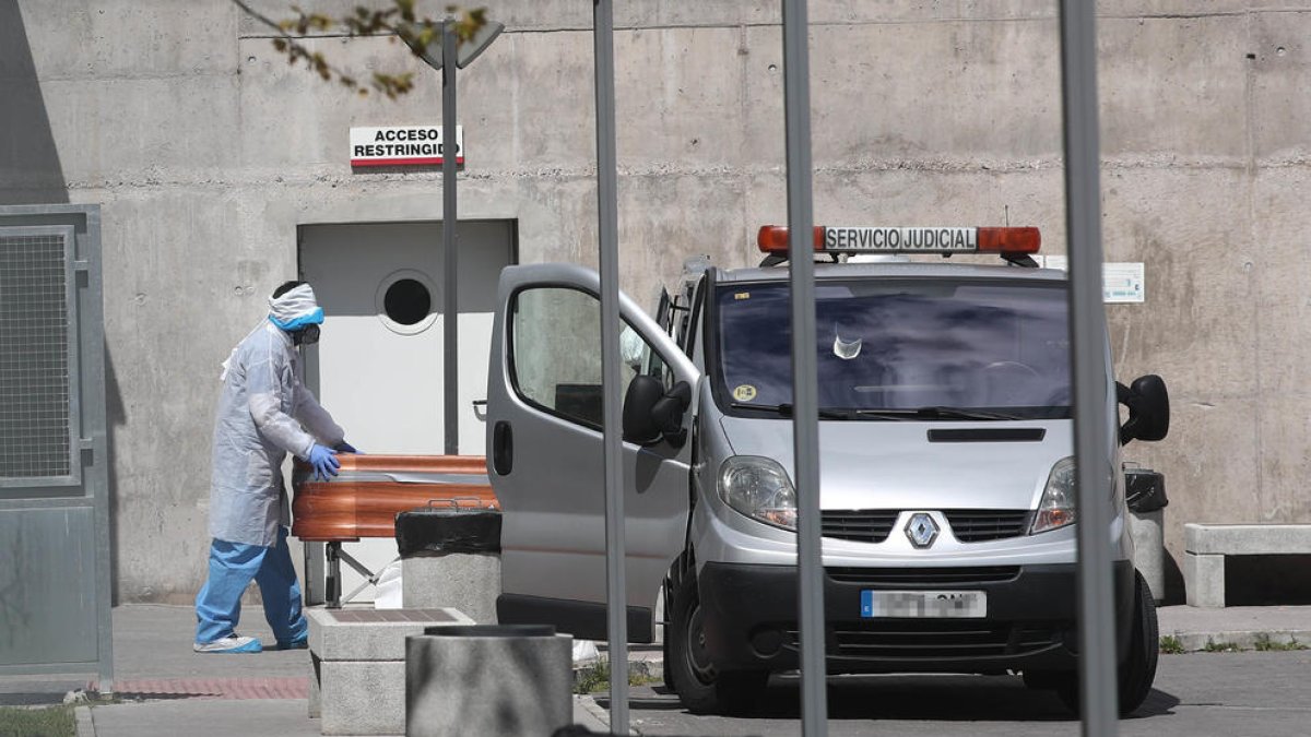 Un operario saca el féretro de una víctima del Covid-19 de una residencia de ancianos, ayer, en Madrid.