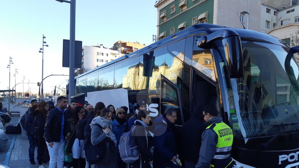 Instant en què un grup de viatgers puja a un dels autobusos que va facilitar Renfe després de l'avaria.