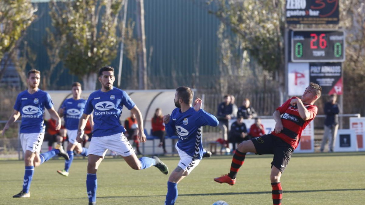 Un jugador de l’EFAC Almacelles intenta controlar la pilota davant de dos rivals del Rapitenca.