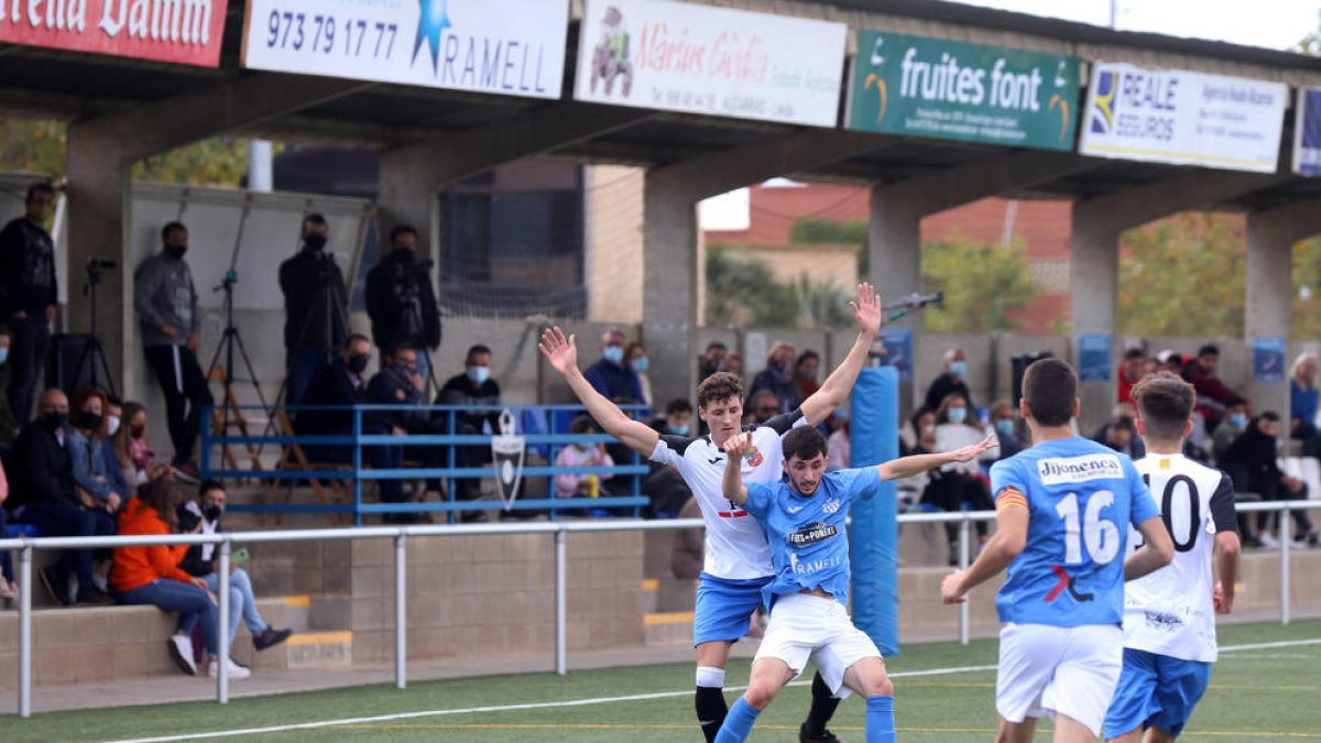 Un jugador de l’Alcarràs protegeix la pilota davant l’intent de recuperació d’un rival del Borges.