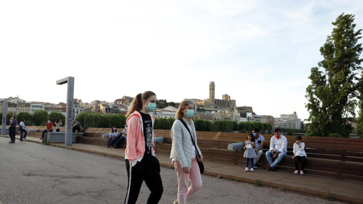 Dos mujeres pasean por la pasarela del Liceu Escolar con mascarilla.