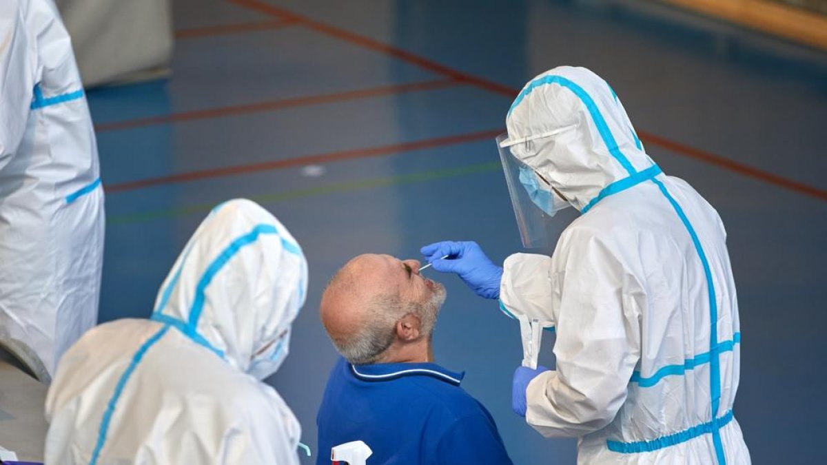 Sanitaris realitzen una prova de detecció del virus a un home a Barcelona.