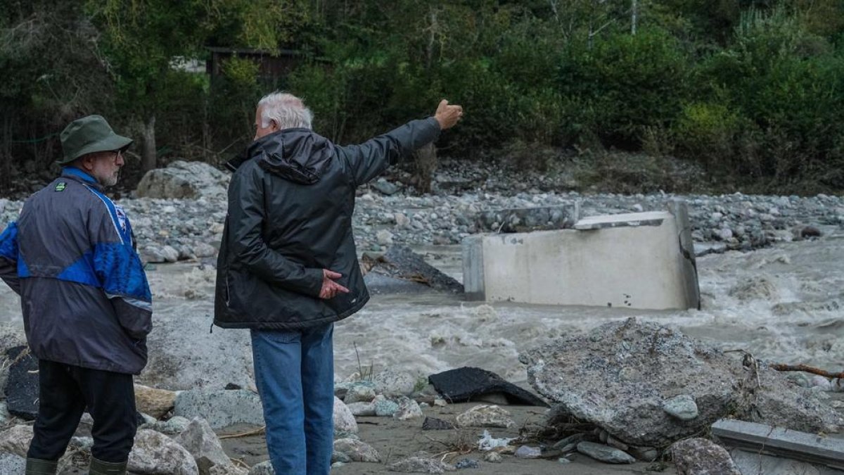 Dos personas observan los destrozos causados por el agua, en Italia.