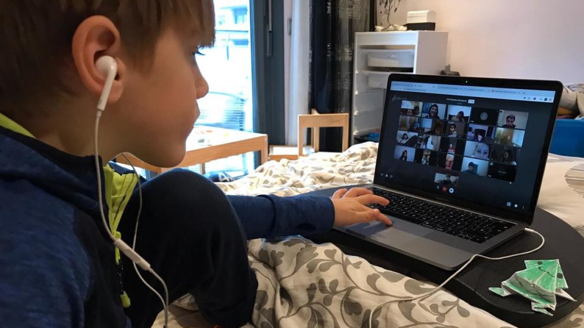 Un niño siguiendo una clase desde casa con el ordenador.