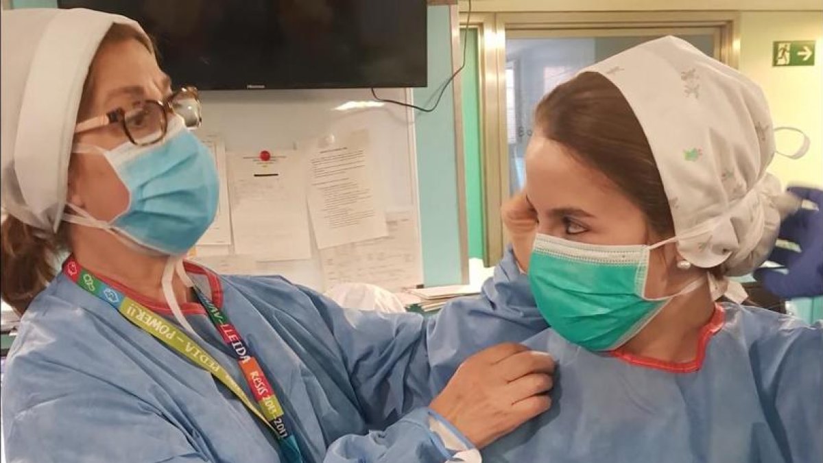 Una sanitària n’ajuda una altra a col·locar-se la mascareta en un centre de Lleida.