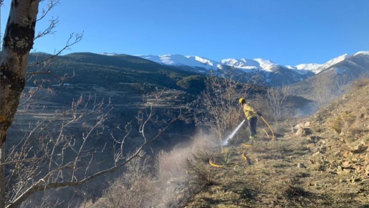 Un bomber sufocant l’incendi a Bellver de Cerdanya.