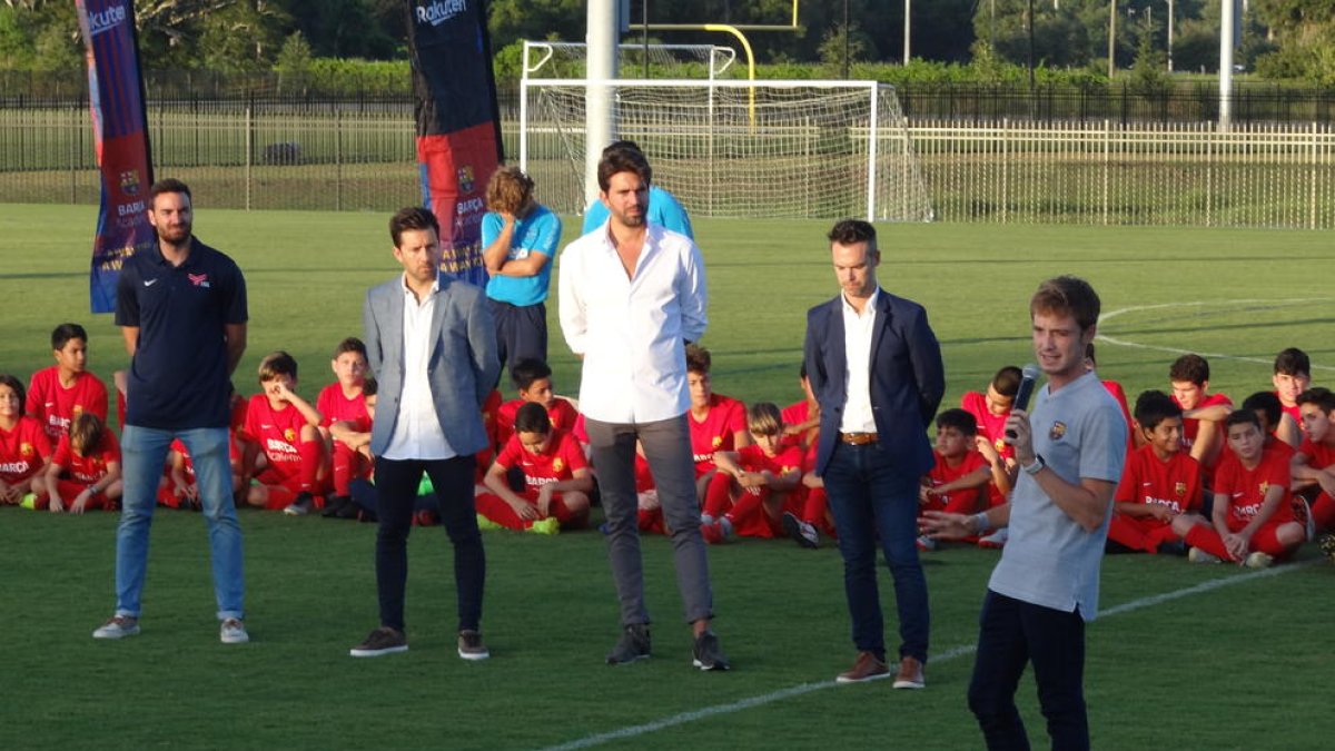 Jordi Aguilar, micròfon en mà, s’adreça a jugadors i tècnics durant una activitat de l’escola.