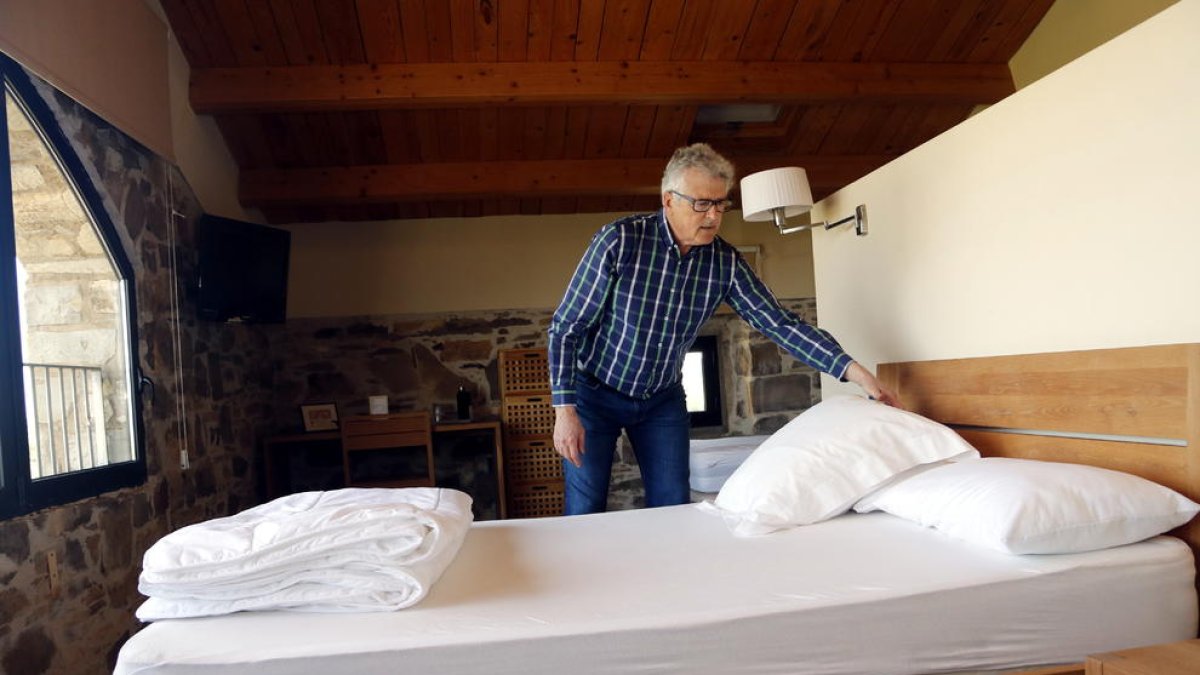 El president de la Federació de Cases Rurals de Lleida, Jaume Ramon, arreglant un llit de la casa rural La Torre del Codina, al Talladell.