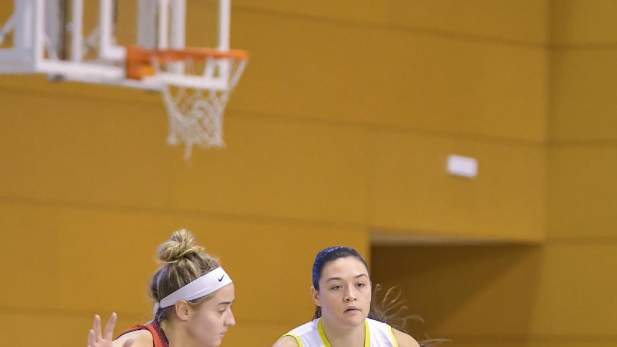 Danni Williams conduce el balón junto a Haley Gorecki.