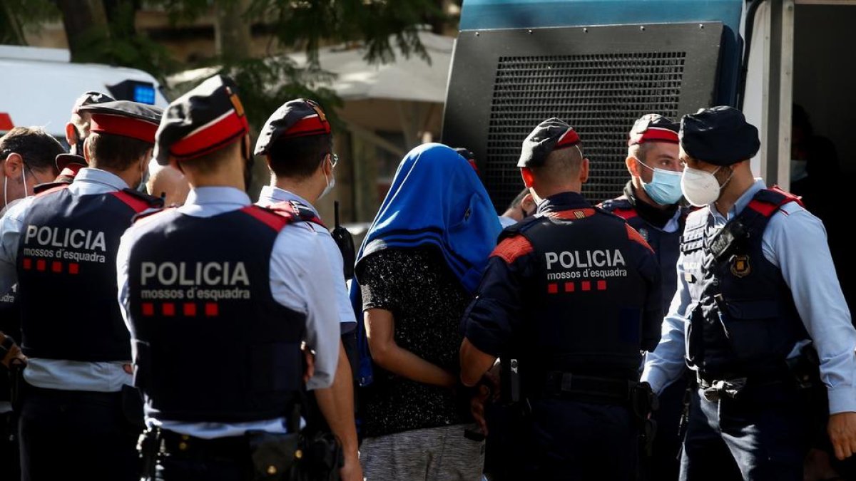 Los Mossos d’Esquadra conducen hacia el furgón a uno de los detenidos en el macrooperativo.